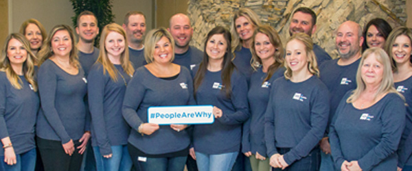 IGS Employees holding #PeopleAreWhy Sign